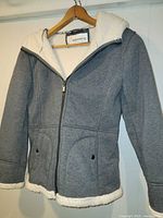 Front view of charcoal grey sherpa-lined hooded coat on hanger