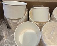 Stacks of 12oz and 8oz white paper cups inside box