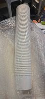 Sleeve of stacked white paper cups wrapped in plastic