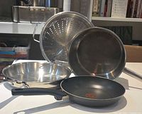 Cookware group: two frying pans, pot, colander and wire strainer