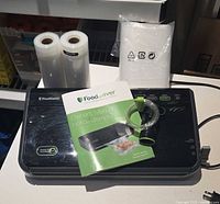 FoodSaver vacuum sealer with two bag rolls, bag pack, hose, manual
