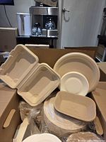 Open box showing various molded fiber plates and clamshells