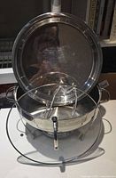 Chafing dish opened showing stainless lid, glass lid, rack and stand