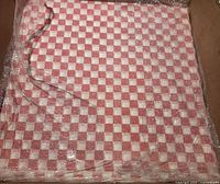 Stack of red checkered paper wraps in shipping box