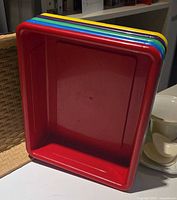 Stack of five coloured trays showing colours and shape
