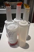 Group of pour bottles and a squeeze bottle on table