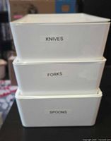 Three white bins labelled Knives, Forks, Spoons stacked