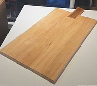 front angled view of rectangular wood charcuterie board on table