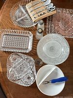 Overview of all glassware, ceramic bowl, pie server, corn holders and shakers on table