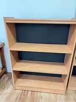 Front view of light wood bookcase with three shelves