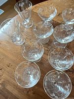 Group of 10 etched crystal stemware pieces on table