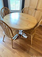 Round pine table with four chairs placed around