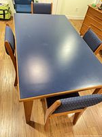 Top view of blue-topped oak dining table and upholstered chairs