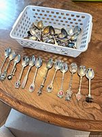 overview of basket and laid-out souvenir spoons on table