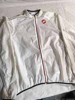 Front view of white Castelli rain shell jacket laid flat