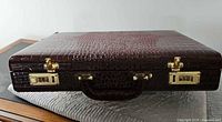 Closed alligator skin briefcase, top view showing texture and locks