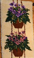 Full view of latch-hook wall hanging showing both violet baskets
