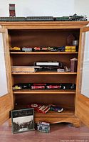 Full bookcase showing multiple shelves of N gauge trains, book and tin