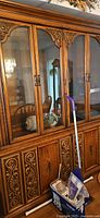 Front view of entire pecan china cabinet showing glass doors and carved lower doors