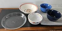 Group shot of pie plate and four bowls displayed on table