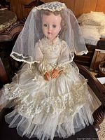 Full view of doll in bridal gown and veil standing