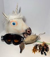 Group shot of unicorn mask, goggles, duck trainer, jigs