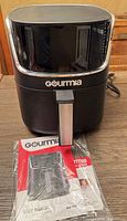 Front view of Gourmia air fryer with user manual