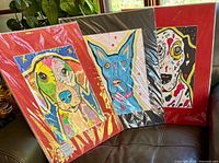 All three matted dog prints wrapped in plastic on sofa