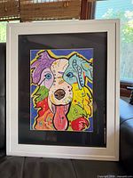 Full view of framed Border Collie artwork with white frame on sofa