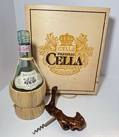 Fratelli Cella box standing behind Chianti bottle in straw with burlwood corkscrew