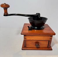 Side view showing wood box, cast iron bowl, crank handle