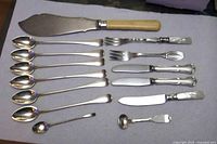 Full set of 14 silver cutlery pieces laid out