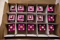 Top view of 15 purple dice ornaments in box compartments