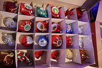 Box showing full set of 24 blown glass ornaments separated in cardboard cells