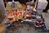 Overall lot view showing two illuminated village buildings and three figurines