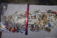 Full bag of assorted Malta stamps spread on surface