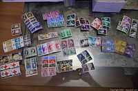 Overview of entire spread of Malta postage stamps in pairs and blocks on table surface