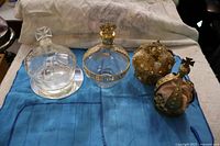 All four items lined on cloth: clear crown bottle, Chambord bottle, two gold crowns