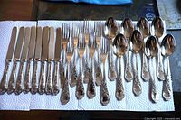 Full layout of 32-piece cutlery set showing knives, forks and spoons