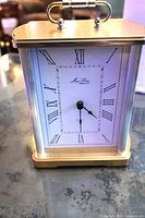 Front view of Jean Louis brass carriage clock showing dial and handle