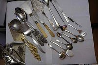 Overview of all 21 assorted silver plate serving pieces laid out