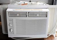 Front view showing Amana branding, vent grille, control knobs and side panels