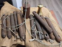 Group of cast iron rod weights, cylindrical eyelet weight, brass weight, burlap bags, steel cable