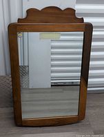 Full view of mirror showing wood frame and shaped crest