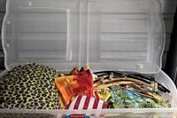 Overview of tote open showing assorted linens and hangers