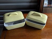 Two covered rectangular yellow Hall Westinghouse casserole dishes on table