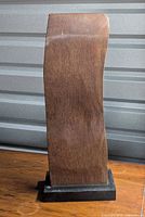 Full view of wooden sculpture on black base