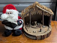 Front view of plush Santa and Holt Howard nativity stable