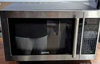 Front view of Sanyo microwave showing door, handle and brand logo