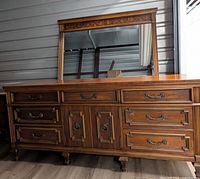 Front view of dresser with mirror frame resting on top showing overall design and finish